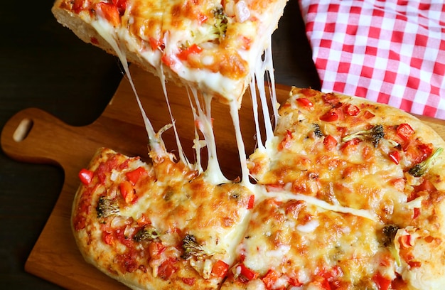 Fatia de pizza caseira Alla Pala com queijo de dar água na boca sendo retirado da tábua de pão