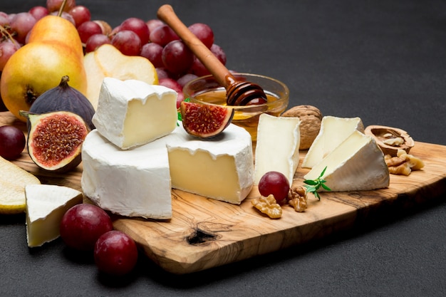 Fatia de queijo brie francês ou camembert e pêra na placa de madeira