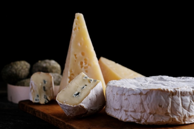 Fatia de queijo de camembert de cabra sortido na mesa de madeira