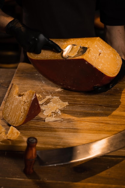 Fatia de sommelier de queijo queijo gouda limitado com fatiador fatiar queijo na loja lanche saboroso pedaço de queijo para aperitivo