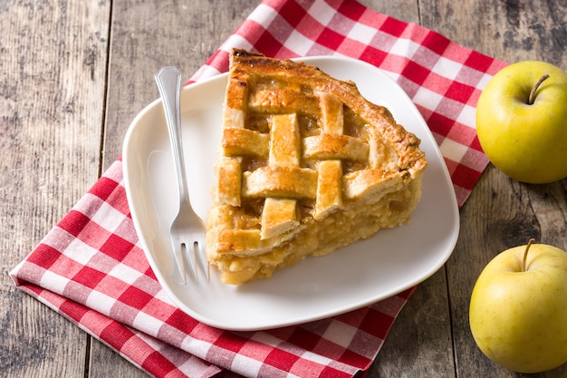 Fatia de torta de maçã caseira isolada na mesa de madeira