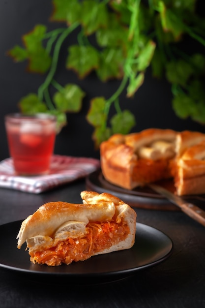 Fatia de torta de repolho caseira fresca com uma bebida refrescante de frutas de verão gelada e plantas atrás