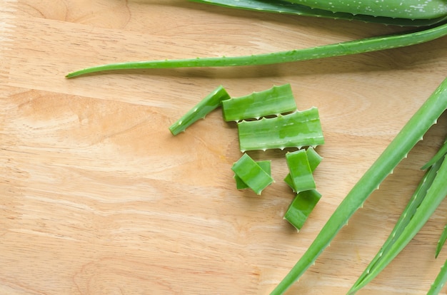 Fatiado e folha de aloe vera fresca no fundo de madeira