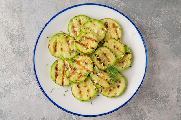 Fatias de abobrinha frita com alho e endro fresco Prato saudável vegetariano Foco seletivo