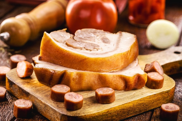 Fatias de bacon cru e salsicha de porco carne de porco na mesa de madeira de porco do brasil