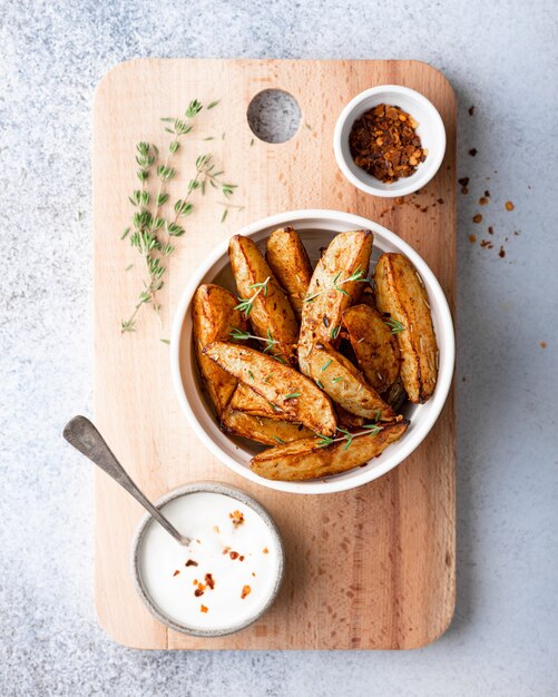 Fatias de batata assada com molho em um fundo claro, vista de cima