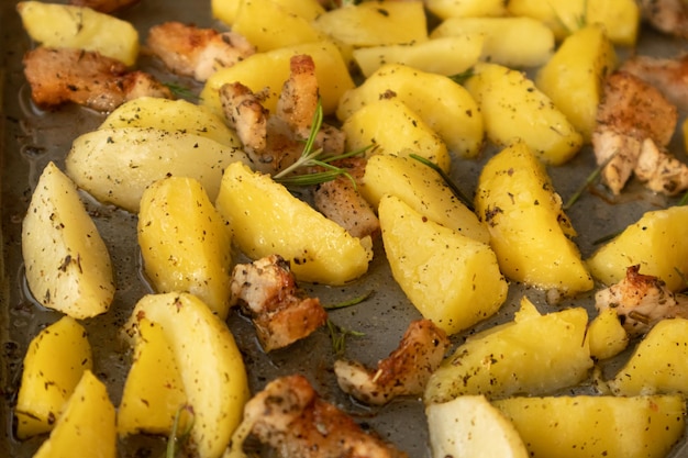 Fatias de batata assadas no forno com rosmaninho em uma assadeira