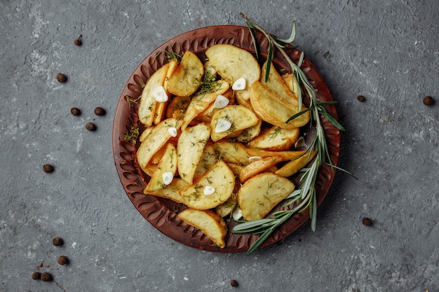 Fatias de batata com alecrim e alho assado em um prato