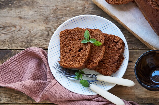 Fatias de bolo de chocolate caseiro com hortelã fresca em um prato branco