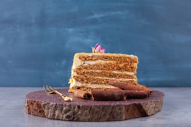 Fatias de bolo de mel doce com paus de canela na superfície da pedra.