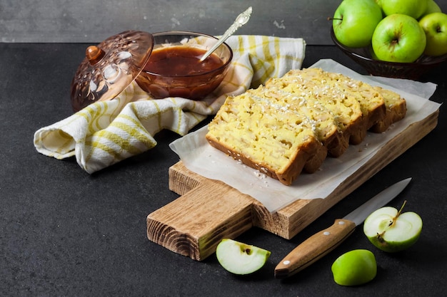 Fatias de bolo de nabo de coco e maçã em uma tábua de madeira em fundo escuro