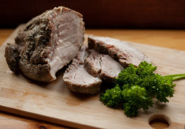 Foto fatias de carne assada em tabuleiro com salsa