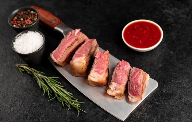 Fatias de carne grelhada em uma faca sobre um fundo de pedra