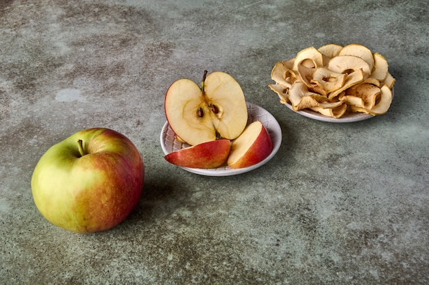 Fatias de chips de maçã e frutas de maçã no foco seletivo de vista de perspectiva de fundo de madeira rústica