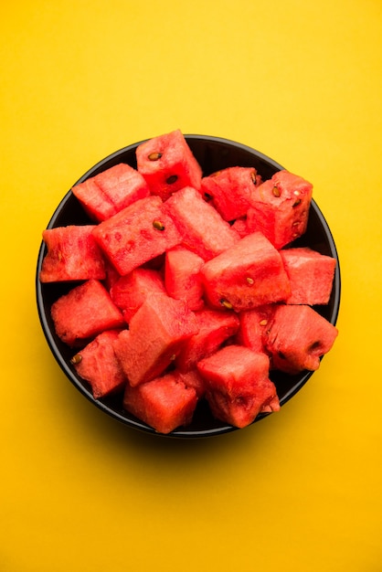 Foto fatias de cubos de frutas melancia ou tarbooj servidas em uma tigela. foco seletivo