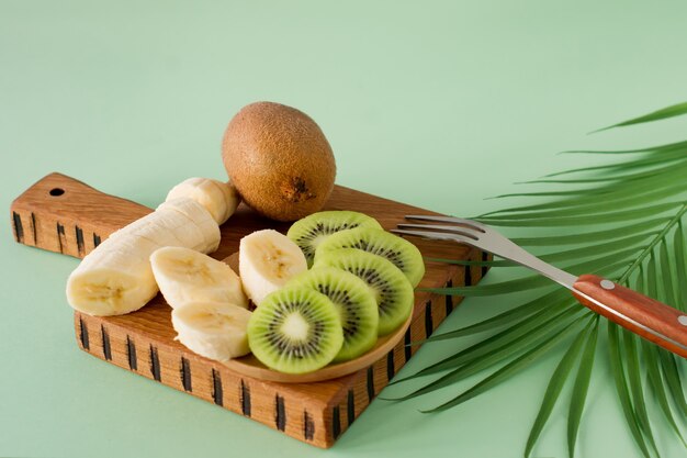 Fatias de frutas exóticas em uma tábua de madeira, close-up. Kiwi e banana slised para cozinhar smoothie. Rico em vitaminas e frutas frescas, alimentos orgânicos saudáveis.