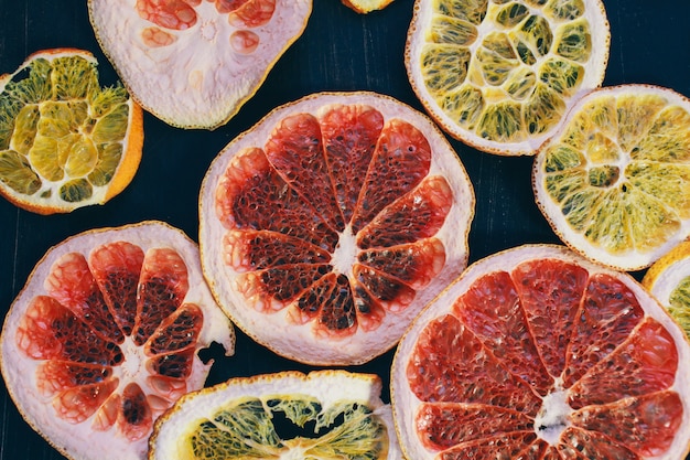 Fatias de frutas (laranja, grapefruitapple). Idéia criativa e estilo minimalista, fundo escuro, com espaço de cópia. Conceito de comida