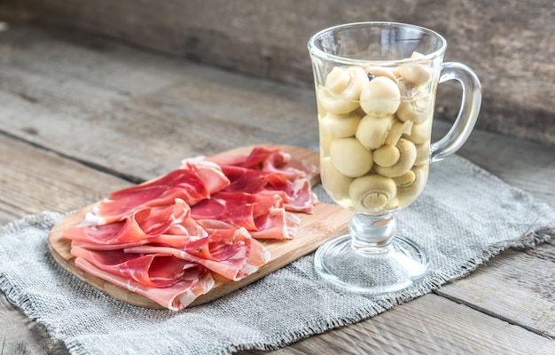 Fatias de jamon na placa de madeira