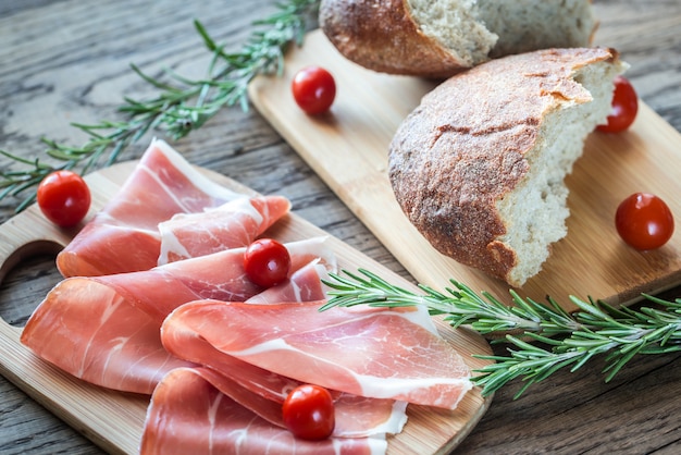 Fatias de jamon na placa de madeira