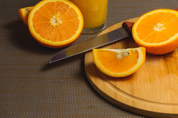 Fatias de laranja com faca na tábua de madeira