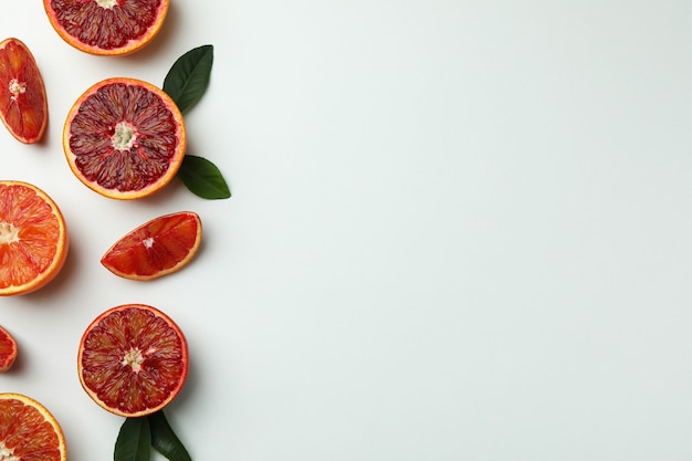 Fatias de laranja vermelha com folhas em fundo branco isolado