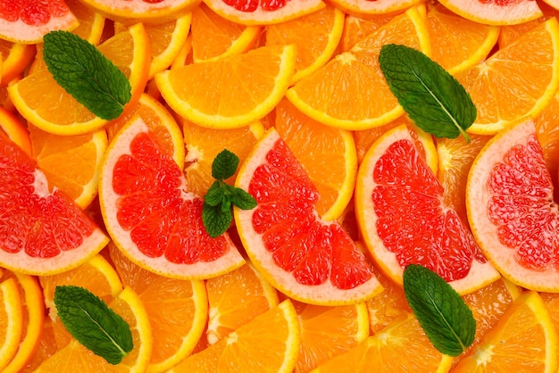 Fatias de laranjas e toranjas e hortelã como pano de fundo