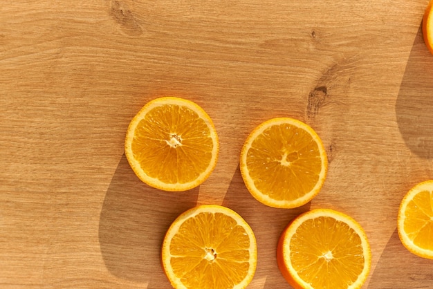 Fatias de laranjas orgânicas frescas em uma mesa de cozinha de madeira.