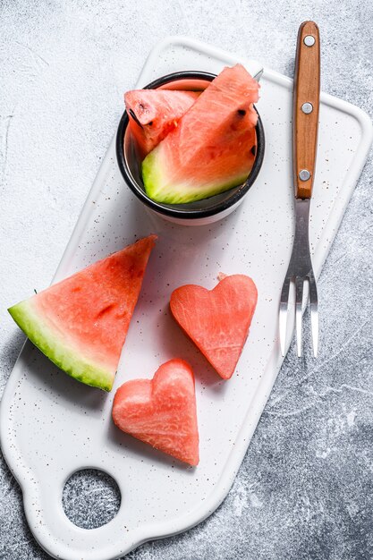 Fatias de melancia em forma de coração. Conceito de amor. Fundo cinza