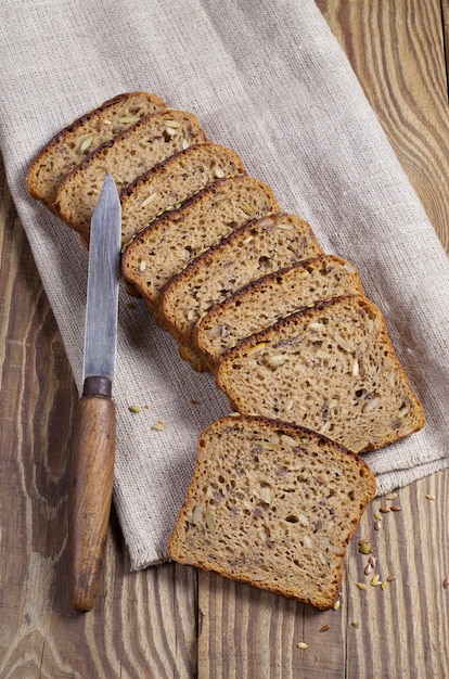Foto fatias de pão com diferentes sementes e uma faca