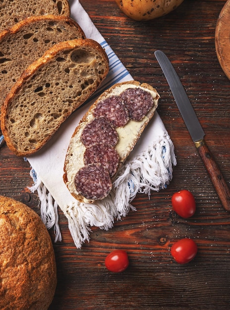 Foto fatias de pão com manteiga e salame