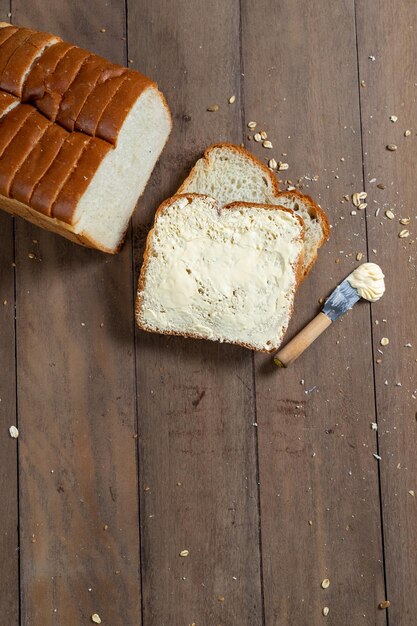 Fatias de pão com margarina em uma mesa de madeira