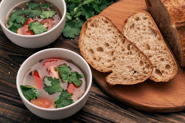 Fatias de pão e dois pratos de sopa na mesa da cozinha