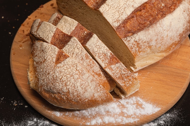 Foto fatias de pão fresco em uma placa de madeira.