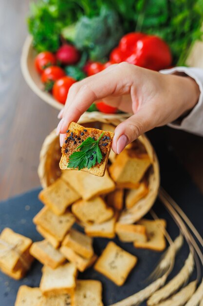 Fatias de pão torrado e patê em mãos femininas Croutons frescos feitos de farinha integral