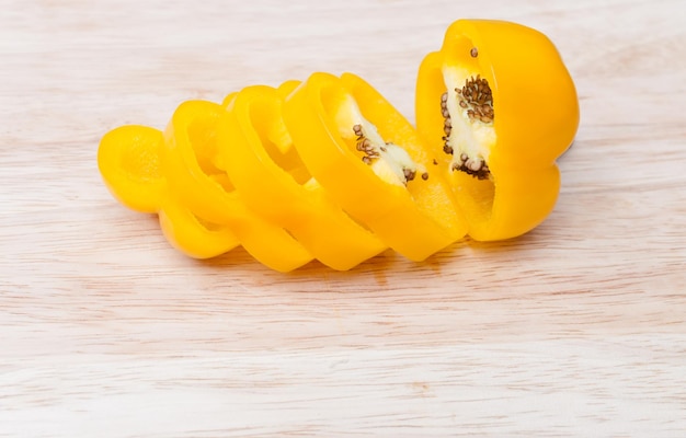 Fatias de pimentão amarelo na tábua de madeira