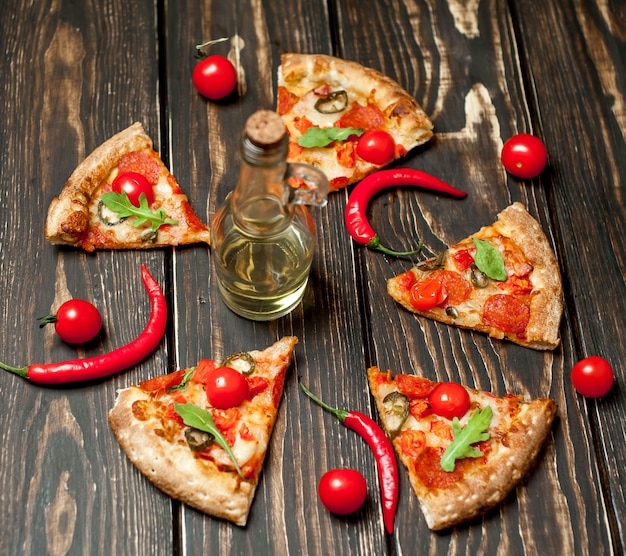 fatias de pizza de calabresa com ingredientes em fundo madeira