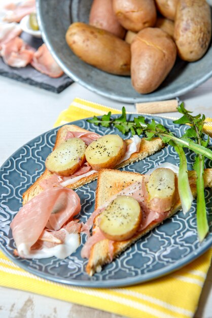 Fatias de presunto e batatas no prato azul