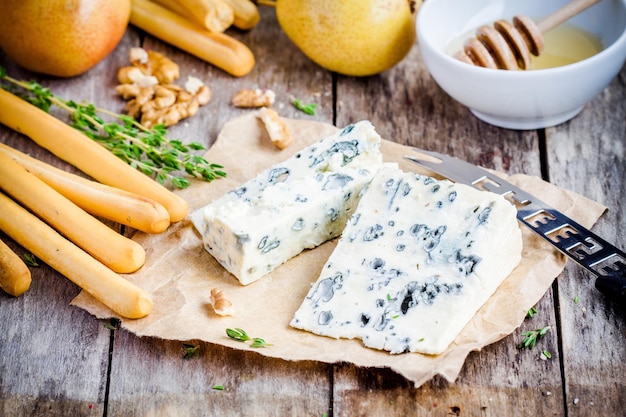 Fatias de queijo azul em papel com nozes e mel