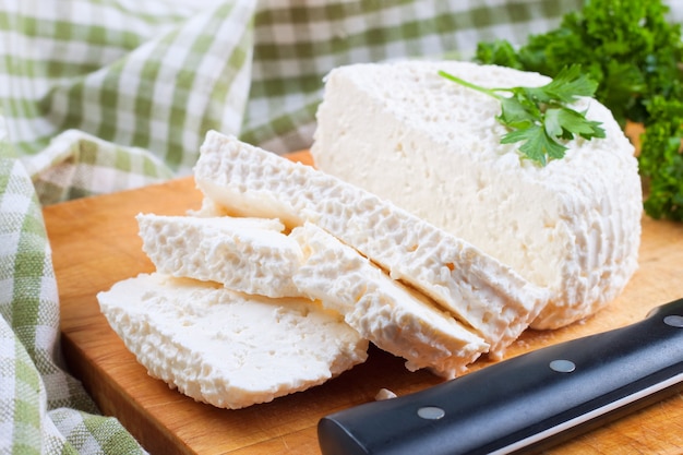 Fatias de queijo fresco na tábua de madeira