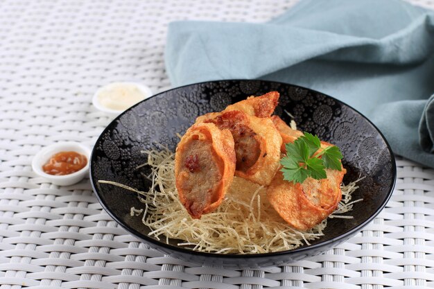 Fatias de rolinhos de ovo de frango, é ovo omelete recheado com frango moído e especiarias, cozido no vapor e frito, servido com molho de maionese de pimenta acima de vermicelli crocante