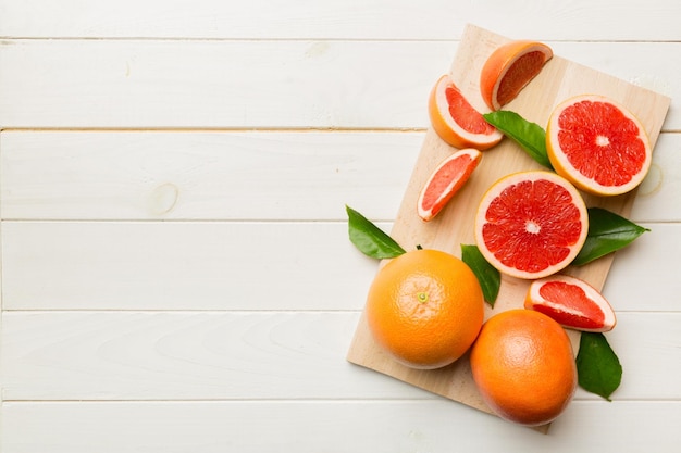 Fatias de toranja de frutas frescas em fundo colorido vista superior conceito criativo de verão do espaço de cópia metade dos cítricos em configuração plana mínima com espaço de cópia