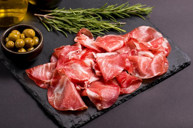 Fatias italianas de coppa, capocollo, capicollo, bresaola ou presunto com alecrim. Comida crua.