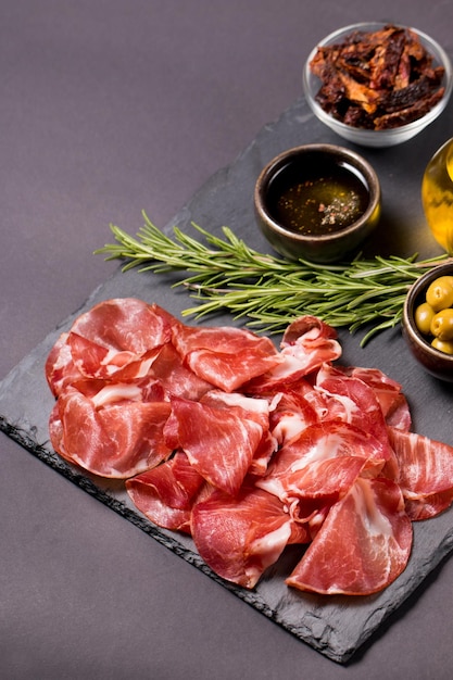 Fatias italianas de coppa, capocollo, capicollo, bresaola ou presunto com alecrim. Comida crua.