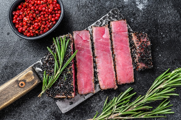 Fatias raras de bife de atum ahi em um cutelo.