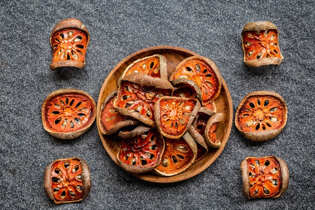 Fatias secas de bael frutas na tigela de madeira