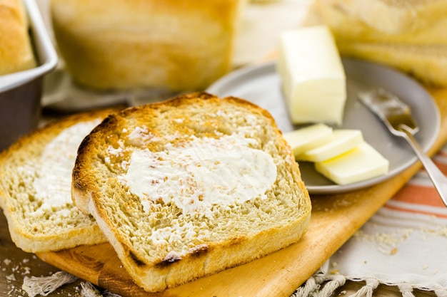 Fatias torradas de pão recém-assado com manteiga.