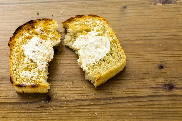 Fatias torradas de pão recém-assado com manteiga.