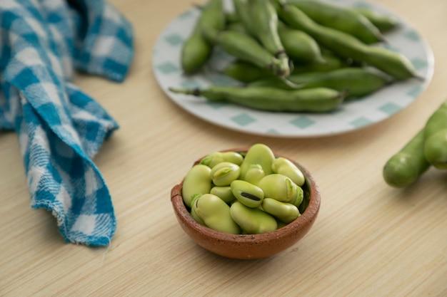 Favas descascadas e descascadas frescas em pratos com espaço de cópia