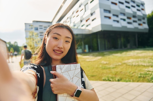 Faz selfie jovem asiática está ao ar livre durante o dia