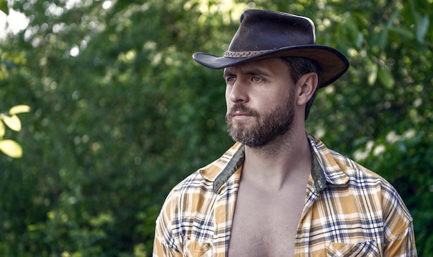 Fazendeiro com chapéu de cowboy homem sexy com camisa xadrez homem ocidental usando chapéu